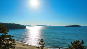 Una playa con agua cristalina, cielo soleado y islas a lo lejos.