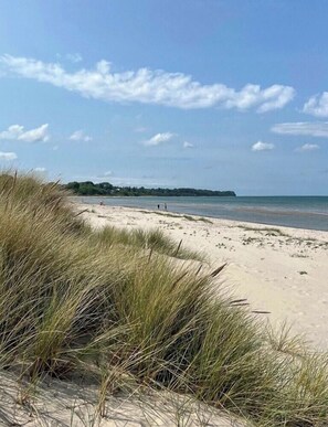Une plage avec des dunes de sable et un ciel dégagé.