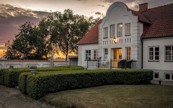 A stately building with a symmetrical facade, a prominent entrance, and a well-maintained garden. - Charming farmhouse with open spaces near Österlen (Löderup)