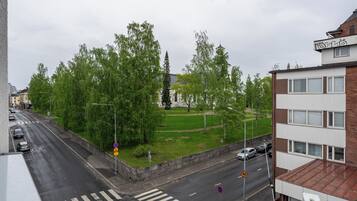 A street view with a pedestrian crossing, cars, and buildings.