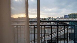A view of a cityscape with a bridge, a parking area, and a building with a sign in a foreign language.
