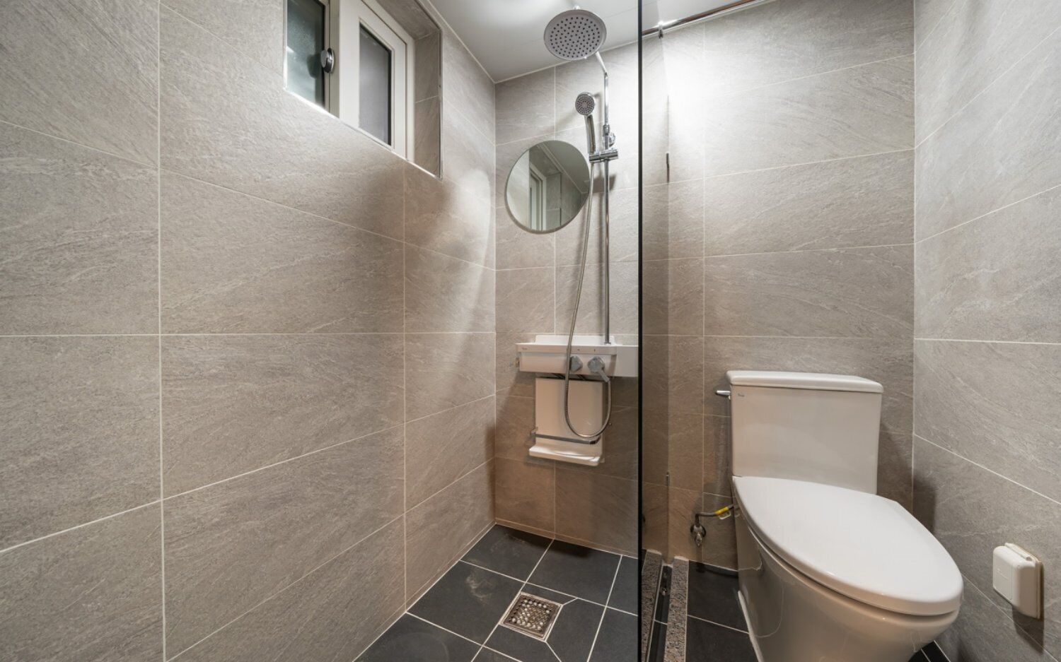 Un bagno con doccia, WC e specchio.