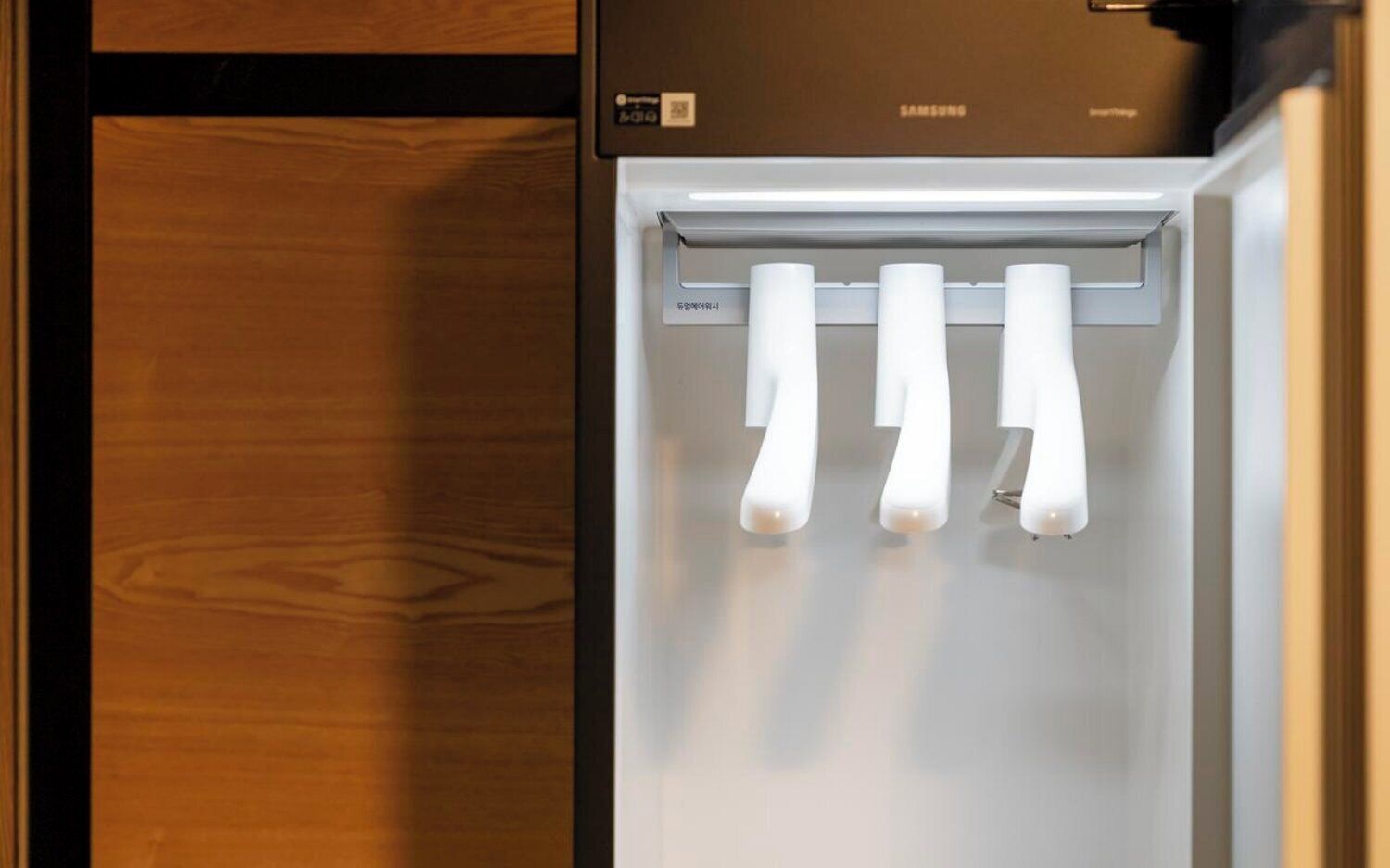 A refrigerator with a Samsung logo, a control panel, and three ice dispensers.