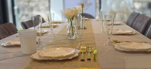 A table set for a formal dining event with clear glassware, white plates, and a decorative centerpiece.