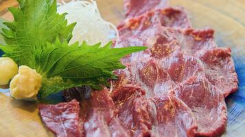 A plate with sliced meat, noodles, and a leaf garnish.