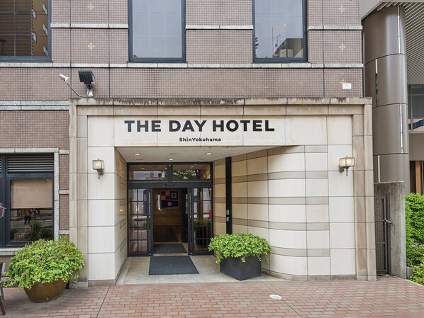L’entrée d’un hôtel, avec une enseigne indiquant : « THE DAY HOTEL ShinYokohama ».