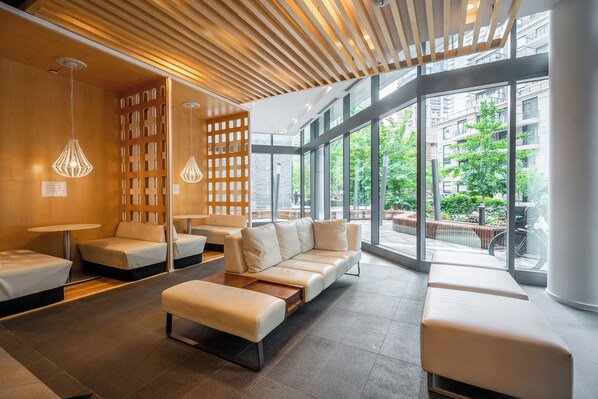 Un intérieur moderne avec un canapé d’angle, des fauteuils et un plafond en bois.