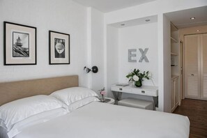Una habitación de hotel con cama, mesita de noche, escritorio y armario.
