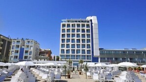 Un hotel con un patio central, zona de estar al aire libre y un edificio moderno de varios pisos.