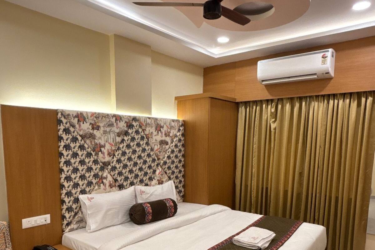 Une chambre d’hôtel équipée d’un lit, d’une table de chevet, d’un téléphone, d’un ventilateur de plafond et d’un appareil de climatisation.
