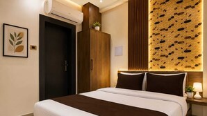 A modern hotel room with a bed, a wardrobe, an air conditioning unit, a wall-mounted light fixture, and a framed artwork. - Hotel shad residency (Patna)