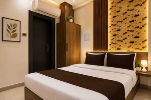 A modern hotel room with a bed, a wardrobe, an air conditioning unit, a wall-mounted light fixture, and a framed artwork. - Hotel shad residency (Patna)