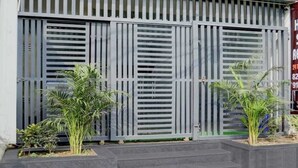 A building facade with vertical slatted metal panels and a gated entrance. - Hotel shad residency (Patna)