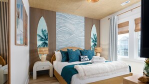 Quarto com cama, mesas de cabeceira, uma janela com cortinas e uma parede com ripas verticais e um mural.