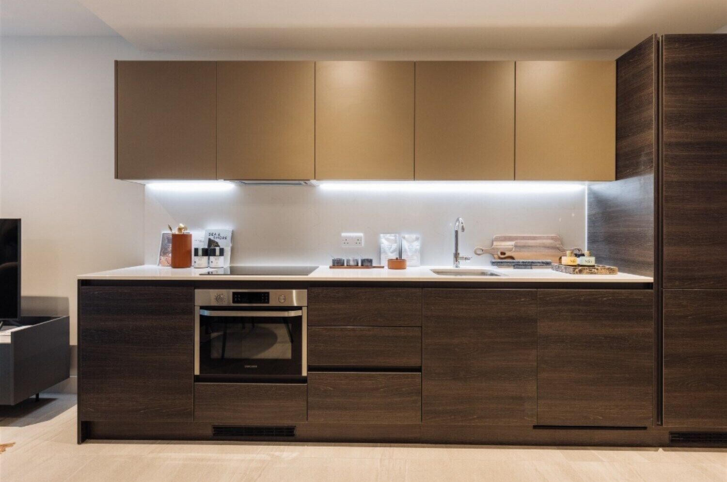 A modern kitchen with built-in appliances, a countertop, and wooden cabinetry.