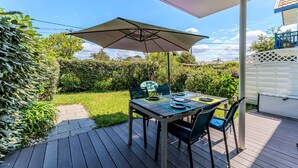 An outdoor patio with a table and chairs, a large umbrella, and a view of the surrounding garden and house. - Bel Air with Private Terrace and Garden, 10-Min Walk to Market (La Teste-de-Buch)