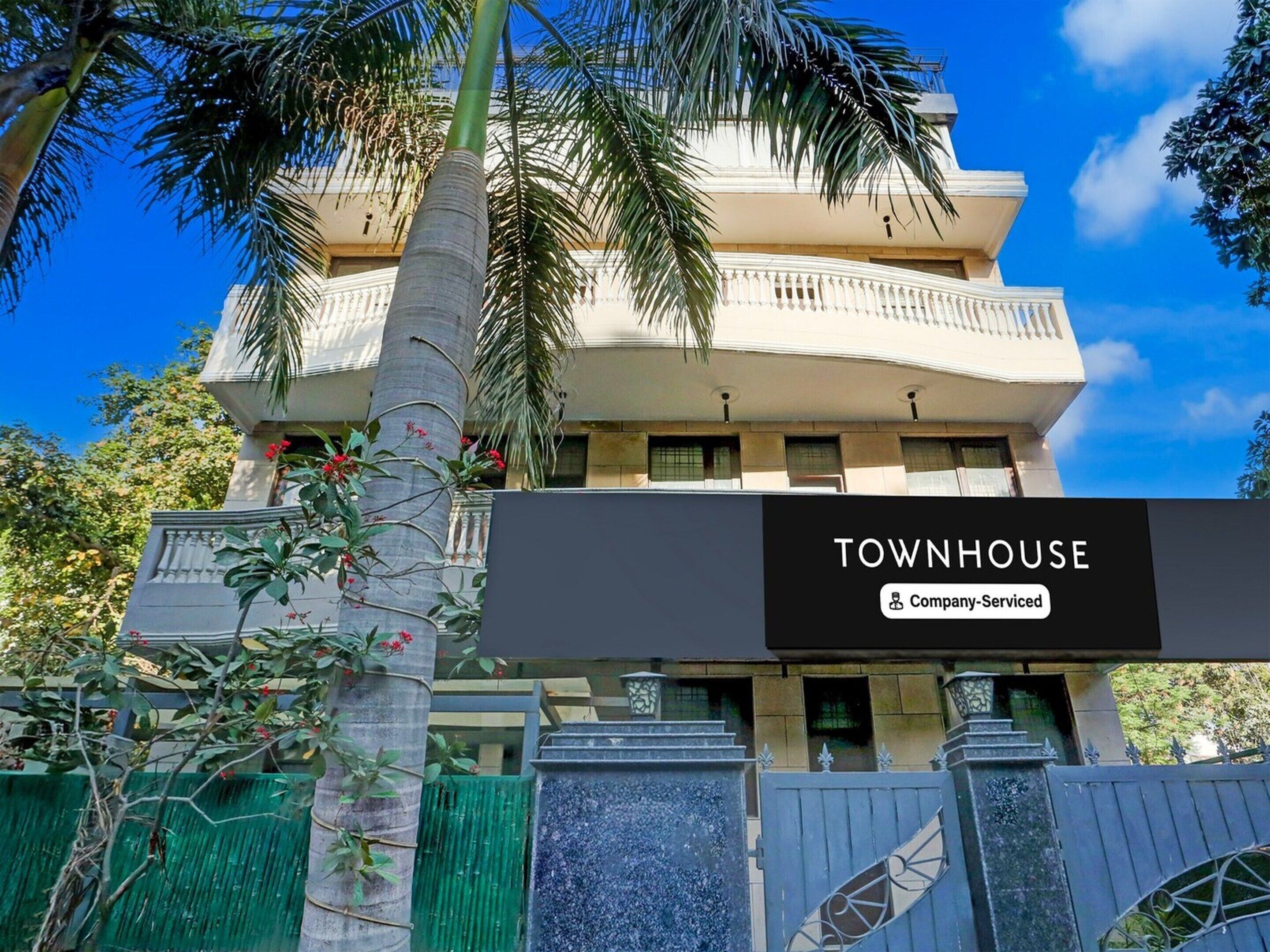 A multi-story building with a sign reading 'TOWNHOUSE Company-Serviced.'