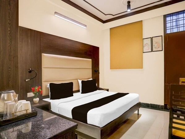 A hotel room with a bed, bedside table, and a chair. - Townhouse Sushant Lok Phase 1 Hotel Neven (Gurugram)