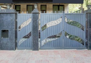 A gated entrance with a decorative metal gate and a stone pillar. - Townhouse Sushant Lok Phase 1 Hotel Neven (Gurugram)