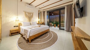 Un dormitorio con cama, mesitas de noche, televisor y vistas al exterior.