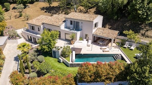 Ein zweistöckiges Haus mit Swimmingpool, Außenbereich und Garten.