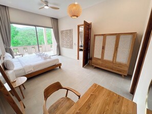 A bedroom with a bed, a wooden wardrobe, a dining table with chairs, and a ceiling fan. - Srithanu Riverside Pool Villa - 3BR (Tambon Ko Pha-ngan)