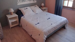 A bedroom with a bed, two bedside tables, a wall mural, and a window with curtains. - Gite La Granica (restored barn) (Bosset)