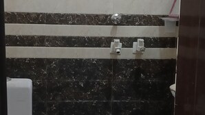 A bathroom with a toilet, a shower, and a sink.