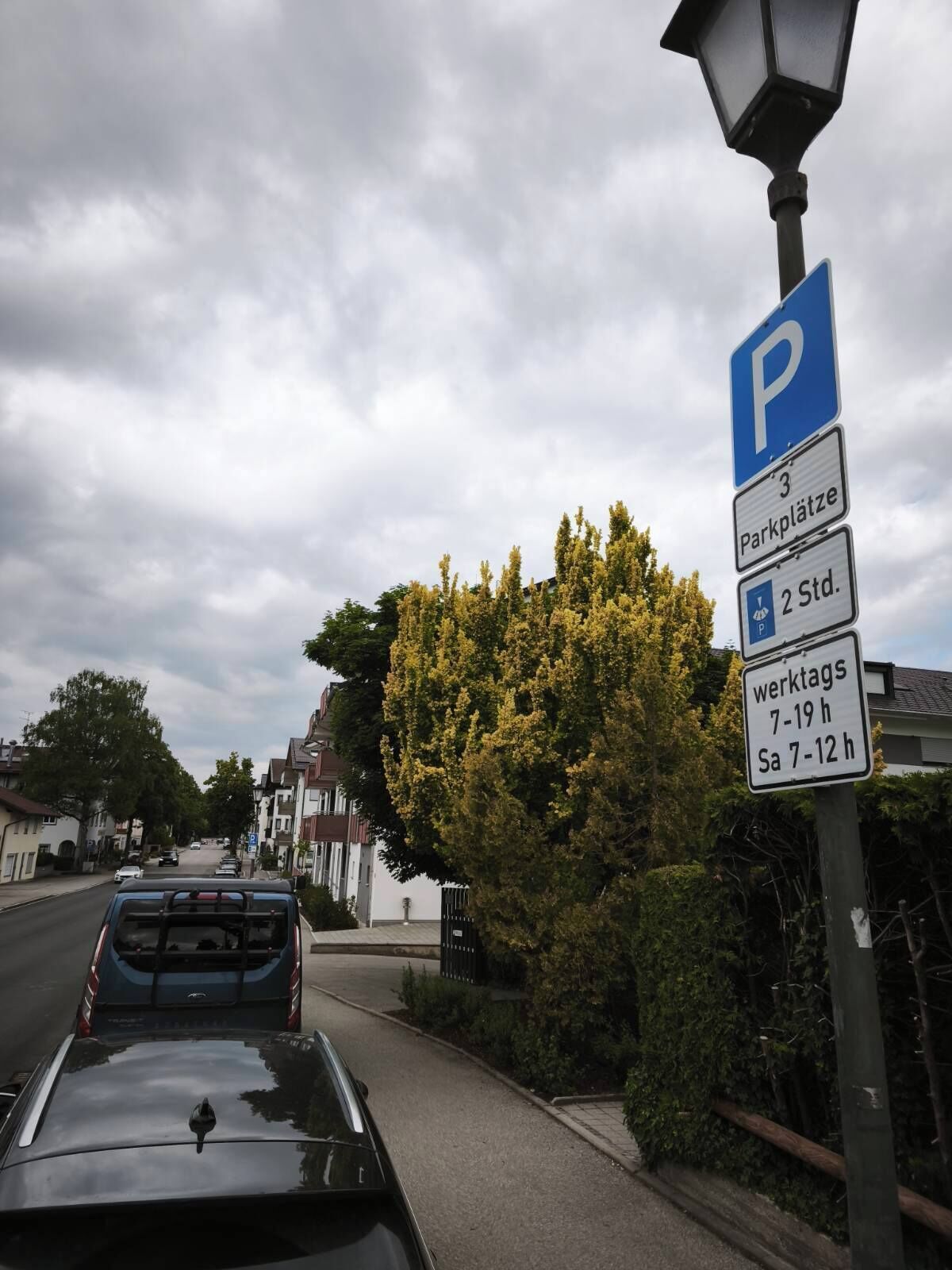 A street view with a parking sign indicating 3 parking spaces, 2 standard spaces, and a 7-19 hour parking limit on weekdays and 7-12 hours on Saturdays.
