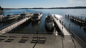 A waterfront pier with boats docked, a clear sky, and a calm body of water. - Apartment with balcony for max. 4 persons (Prien am Chiemsee)