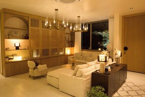 Ein modernes Wohnzimmer mit Sofa, Couchtisch, Beistelltisch und Bücherregal.