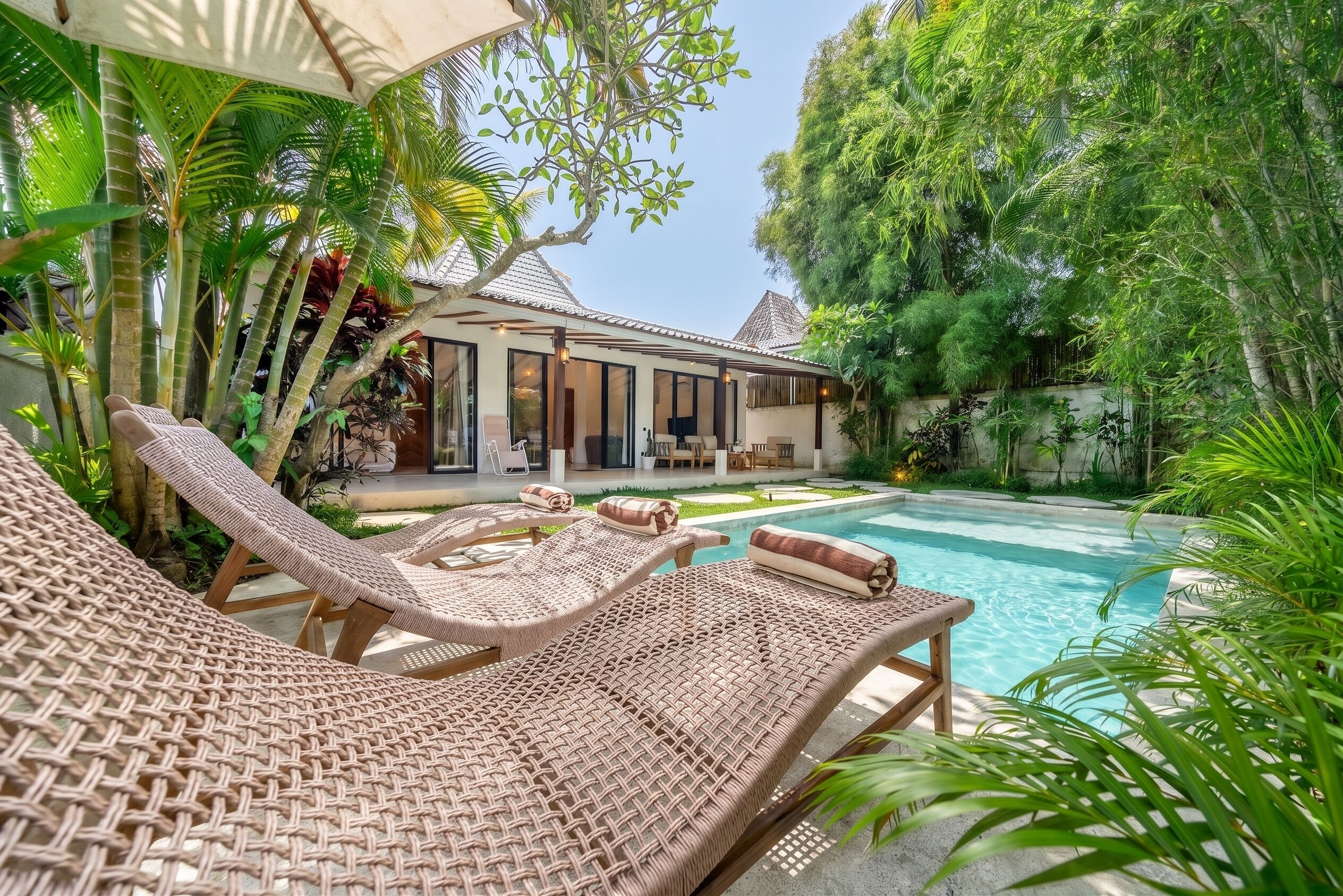 Ein Poolbereich mit Korlounge-Stühlen und freiem Blick auf den Pool.