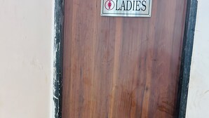 A wooden door with a sign that reads 'LADIES'.