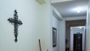 A hallway with a wooden bench, a decorative wall hanging, and a tiled floor. - Apartment in San Salvador (San Salvador)