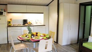 Une cuisine moderne avec des meubles blancs, une table à manger avec des chaises et un coin repas.