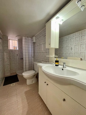A bathroom with a toilet, sink, and mirror. - Casa Katerina studio apartment (Chania)
