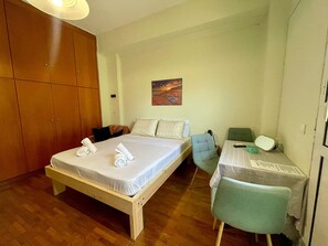 A bedroom with a bed, a chair, a desk, and a wardrobe. - Casa Katerina studio apartment (Chania)