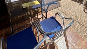 A stone wall, a brick barbecue, and a glass table with chairs. - Casa Zerimar       . (Conil de la Frontera)