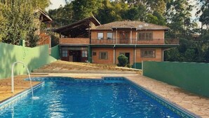 A two-story house with a swimming pool in front. - POUSADA ALL GREEN (Camanducaia)