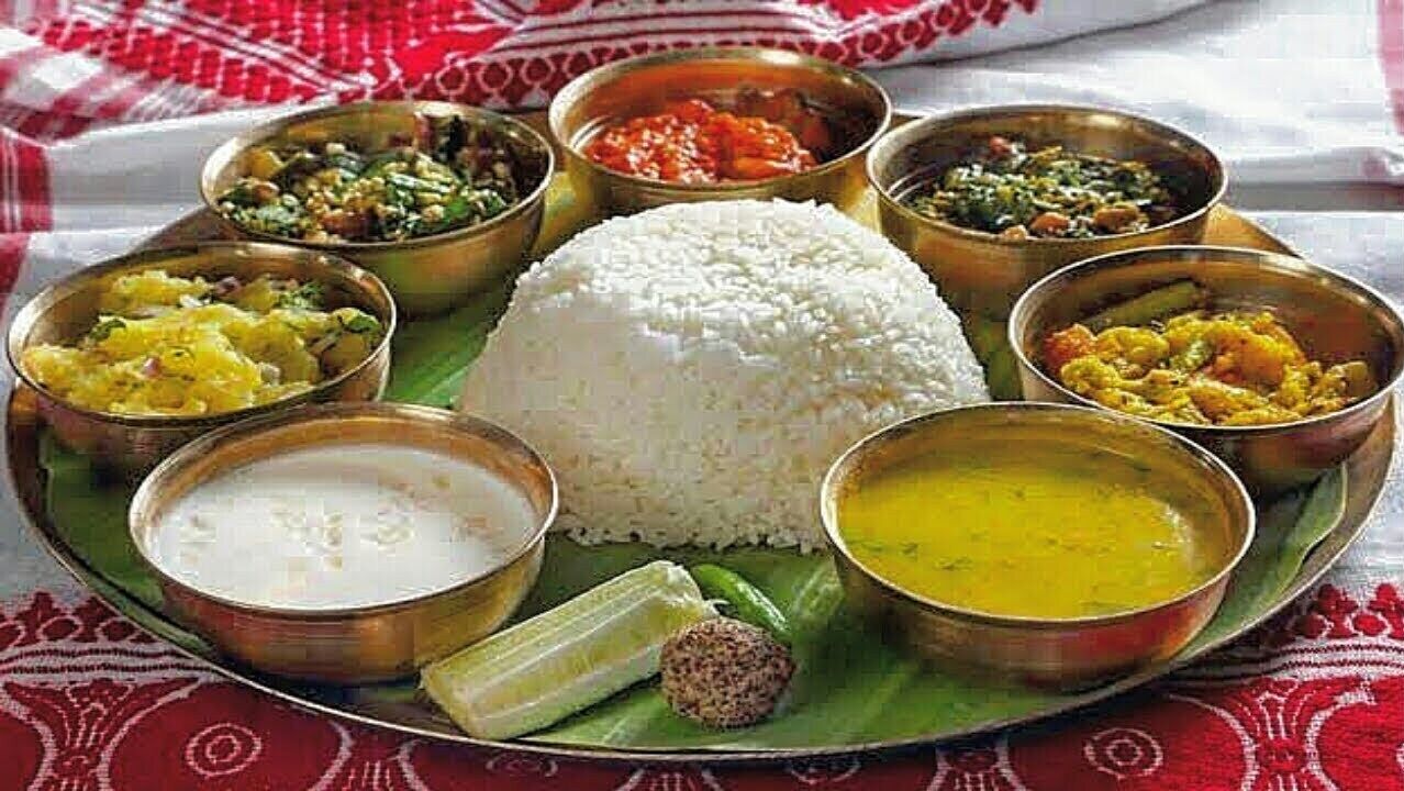 A traditional South Indian meal with rice and various curries, served on a banana leaf.