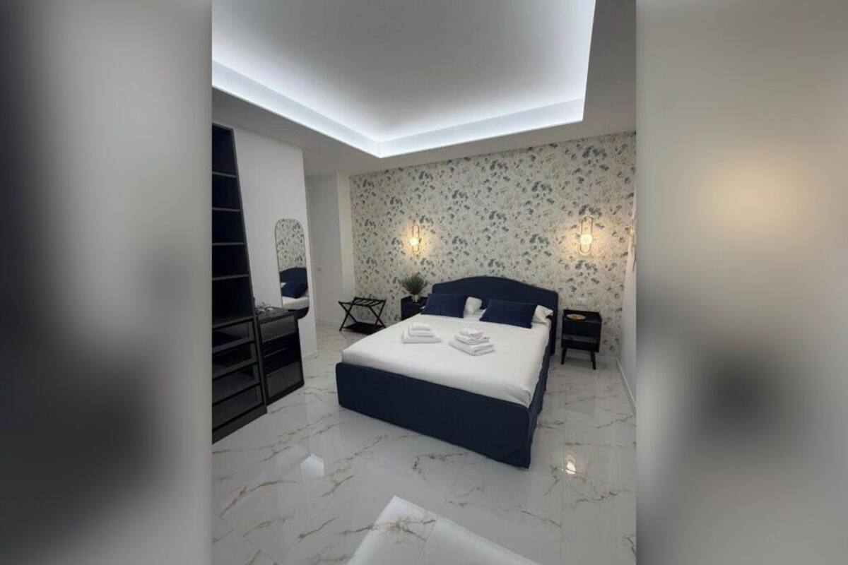 Un dormitorio moderno con una cama grande, un escritorio y una silla.