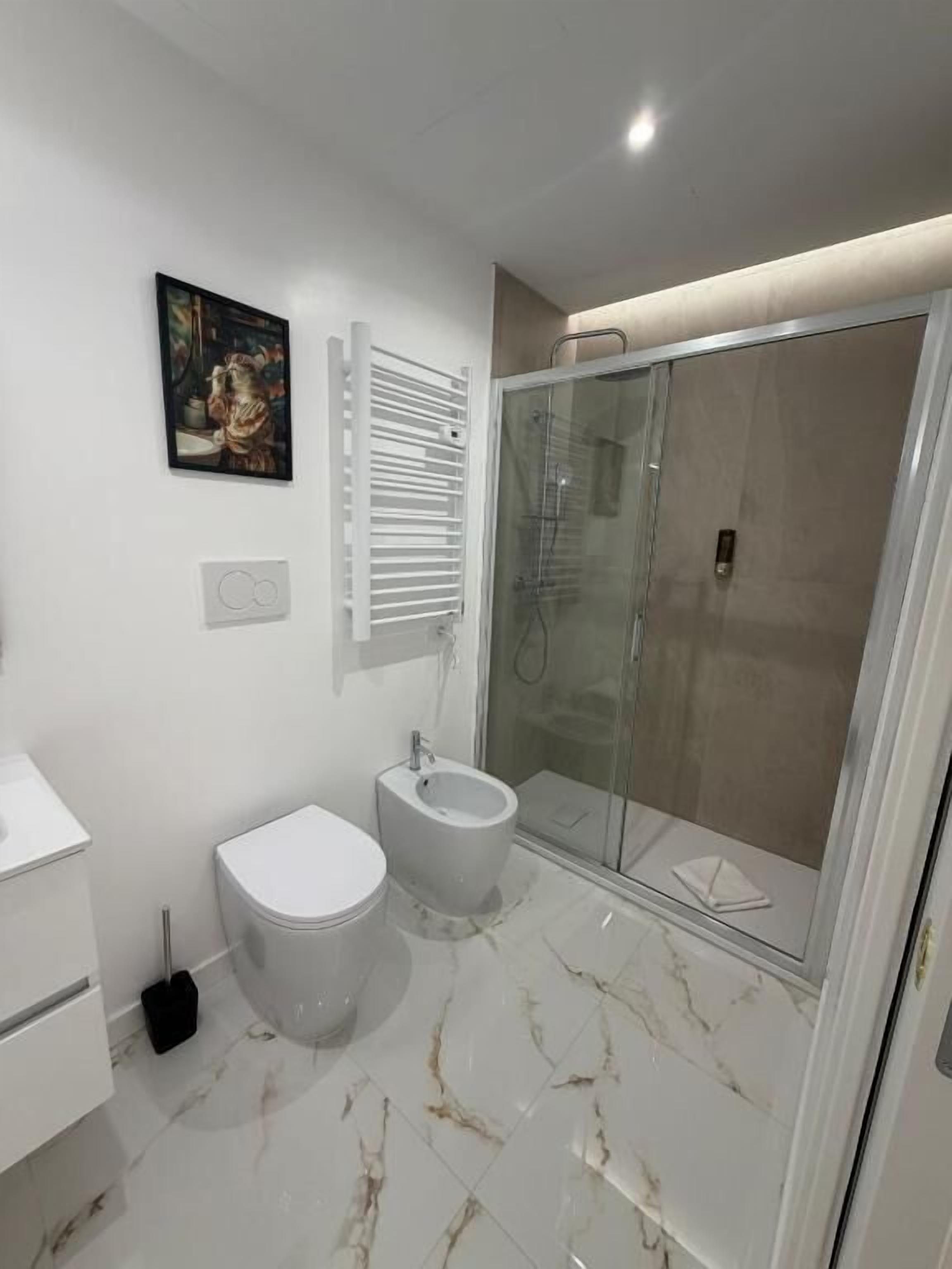 Een moderne badkamer met toilet, bidet en douchecabine.