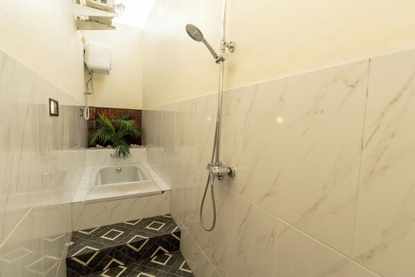A bathroom with a shower, a bathtub, and a small sink.