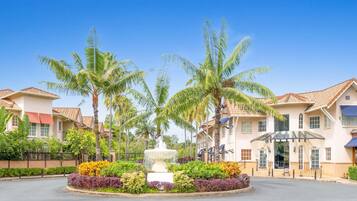A residential area with houses, palm trees, and a central fountain.