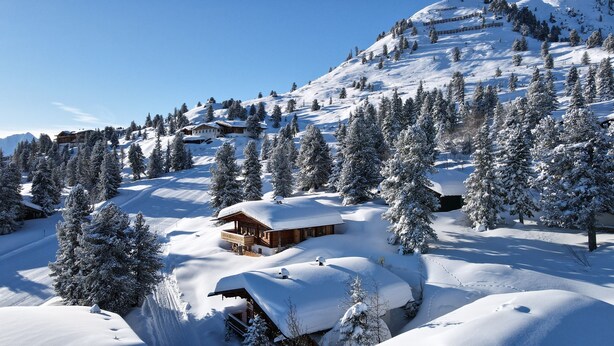 A snow-covered mountain landscape with wooden cabins and pine trees. - Chalet 'Hochzillertal' with Mountain View, Private Terrace and Wi-Fi (Kaltenbach)