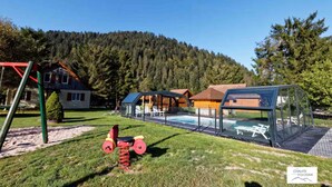 Et boligområde med swimmingpool, legeplads og et hus med rødt tag.