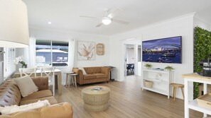 A modern living room with a sofa, coffee table, and TV.