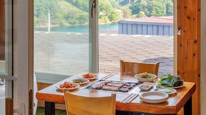 Una mesa de comedor con comida, vista a un lago y decoración de madera.