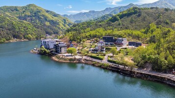 Un resort a orillas del lago con edificios modernos, un puente y abundante vegetación.