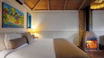 Un dormitorio con una cama grande, una chimenea de ladrillo y un mural colorido en la pared.